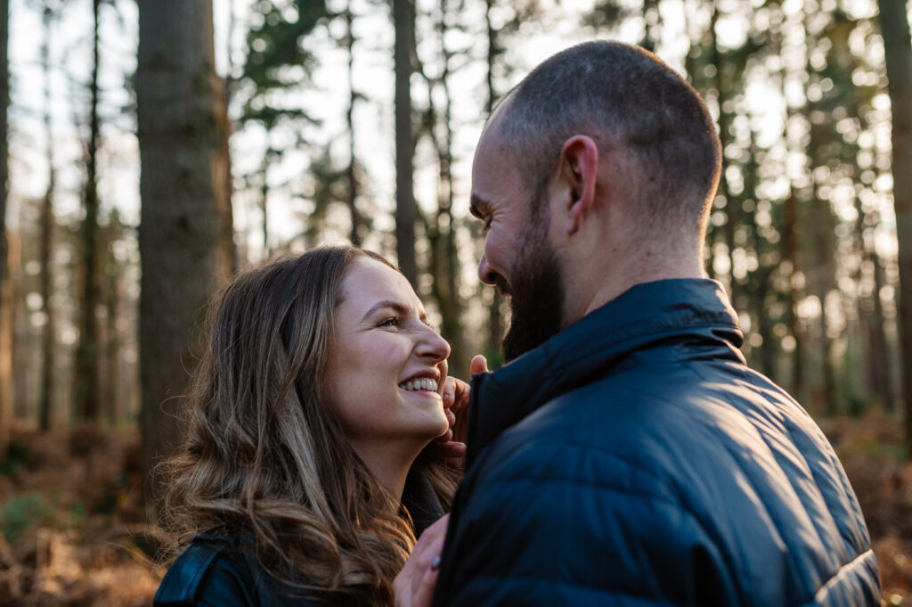 Chelsey looks up into Tom's eyes and they gaze and smile at each other in oakley woods