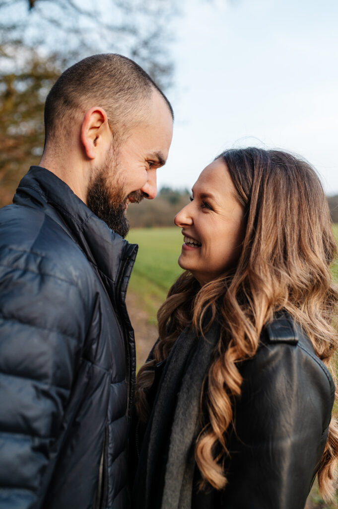 Tom and Chelsey facing each other laughing and smiling in the moment in this shoot in oakley woods