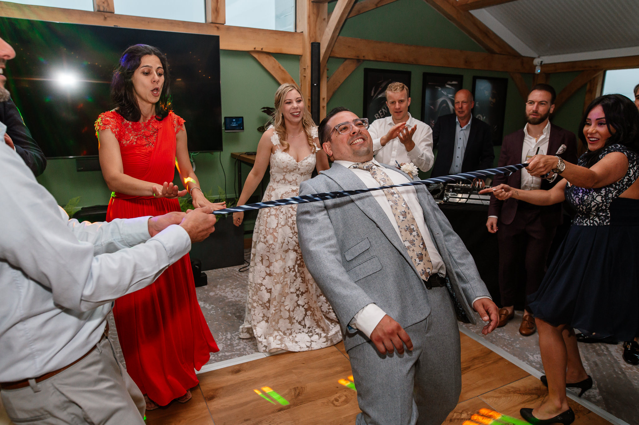 groom doing limbo on the dance floor 