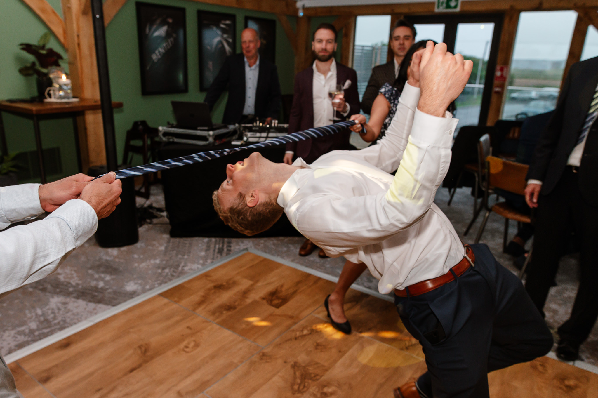 guest doing limbo on the dance floor with a tie 