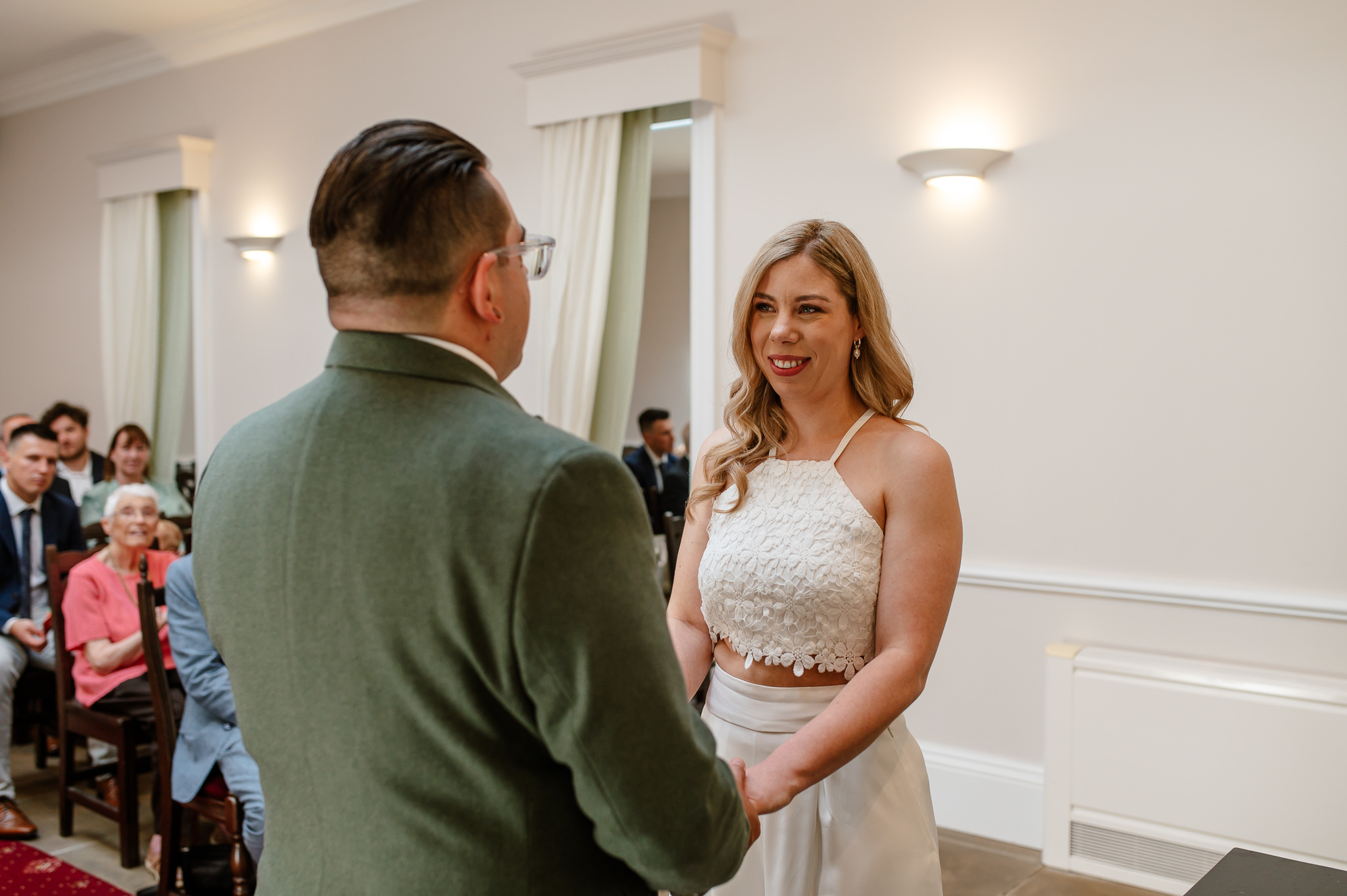 bride and groom hold hands looking at each other during the ceremony at york registry office 