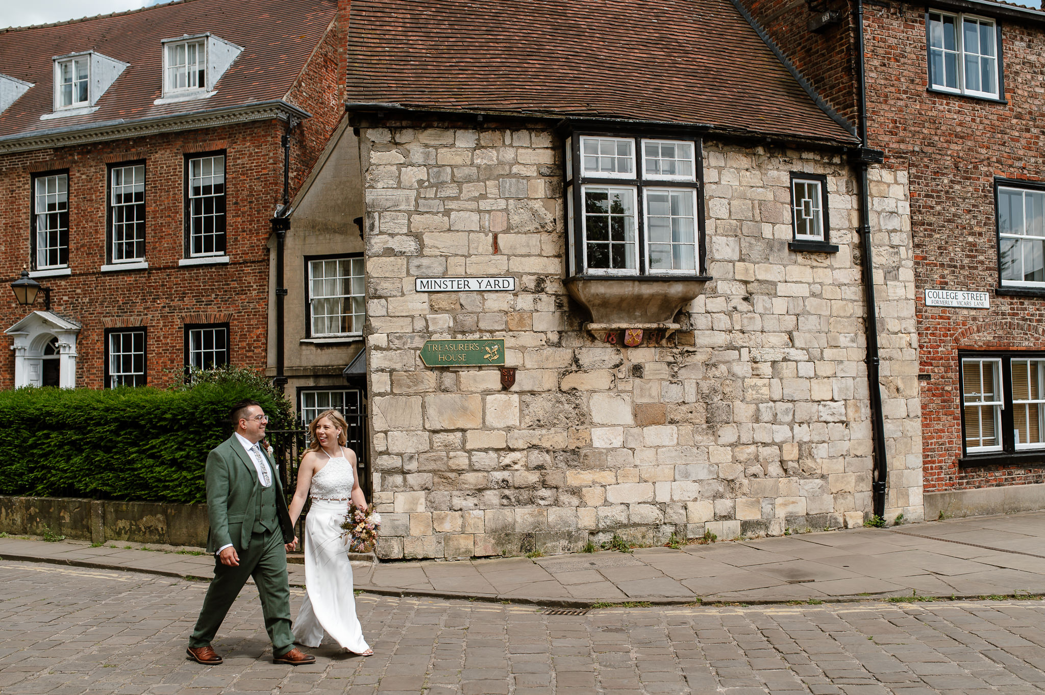 Bride and groom walking and talking at minster yard in york