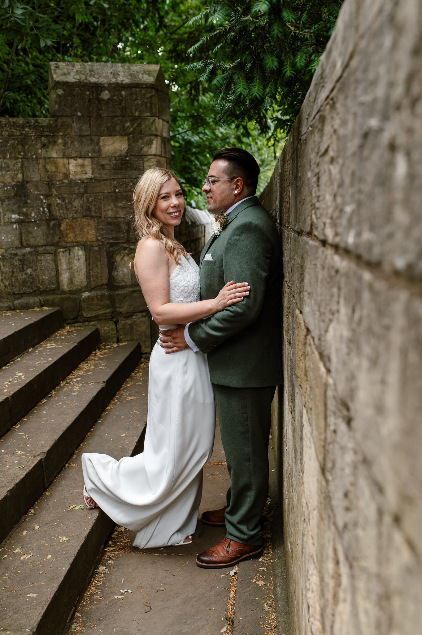 Bride and groom on the york bar walls facing each other and bride looking at the camera 
