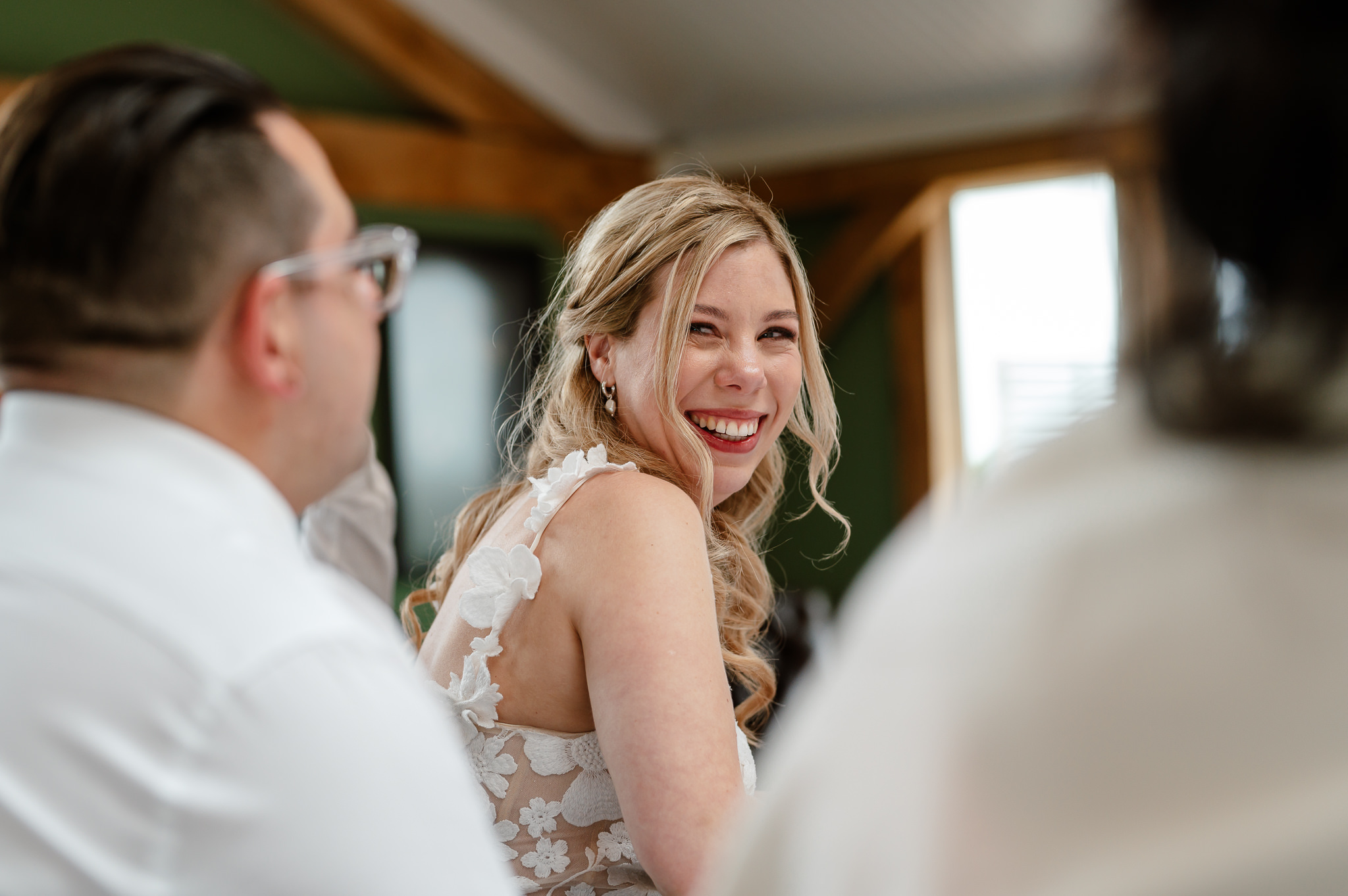 bride candid smiling at the groom during speeches 