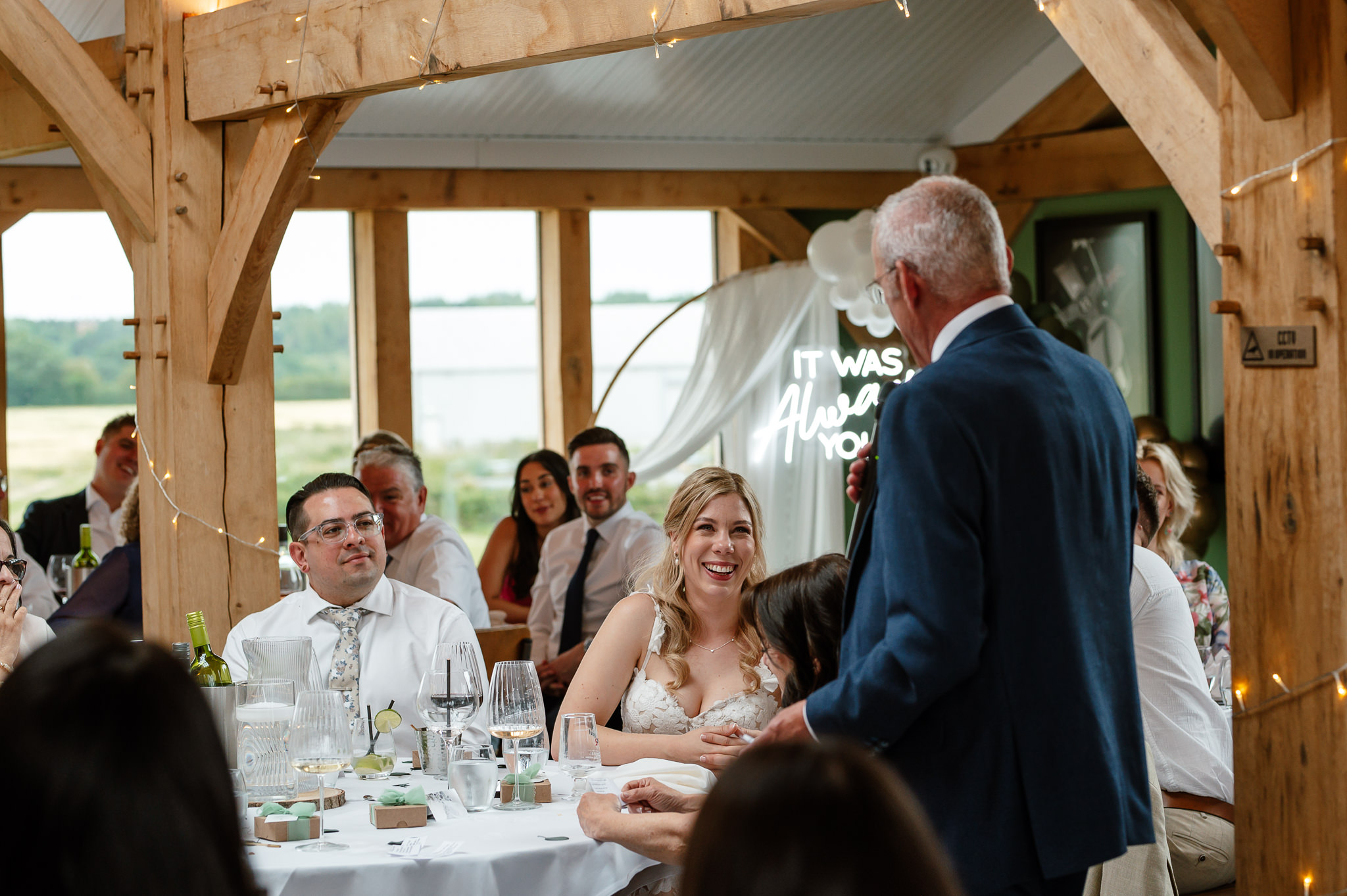 bride laughing at father during his speech 