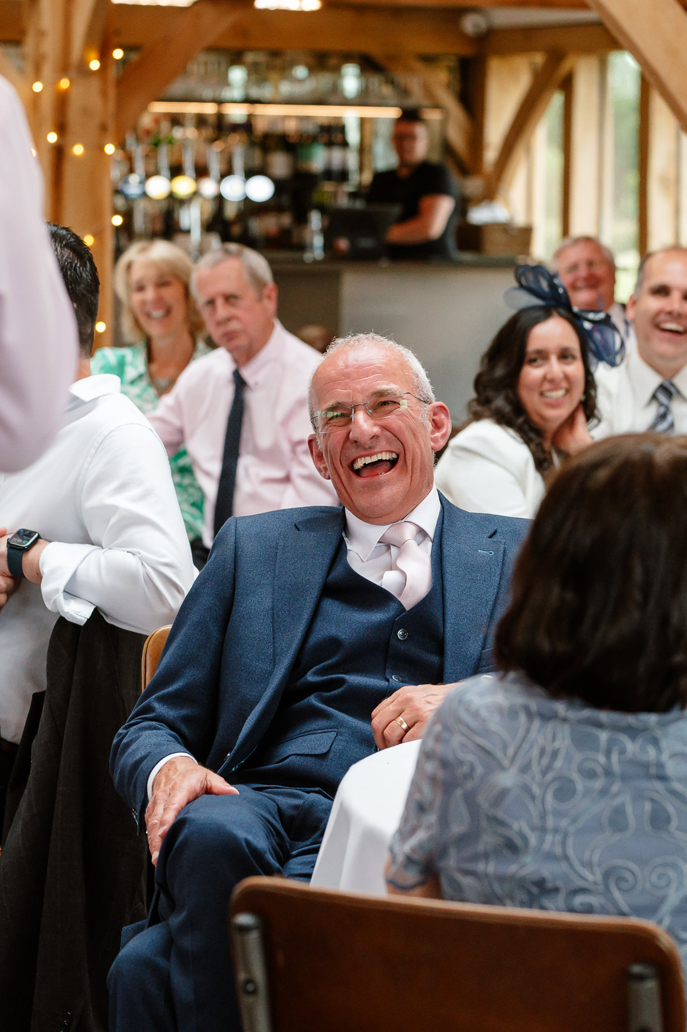 father of the bride laughing during speeches 
