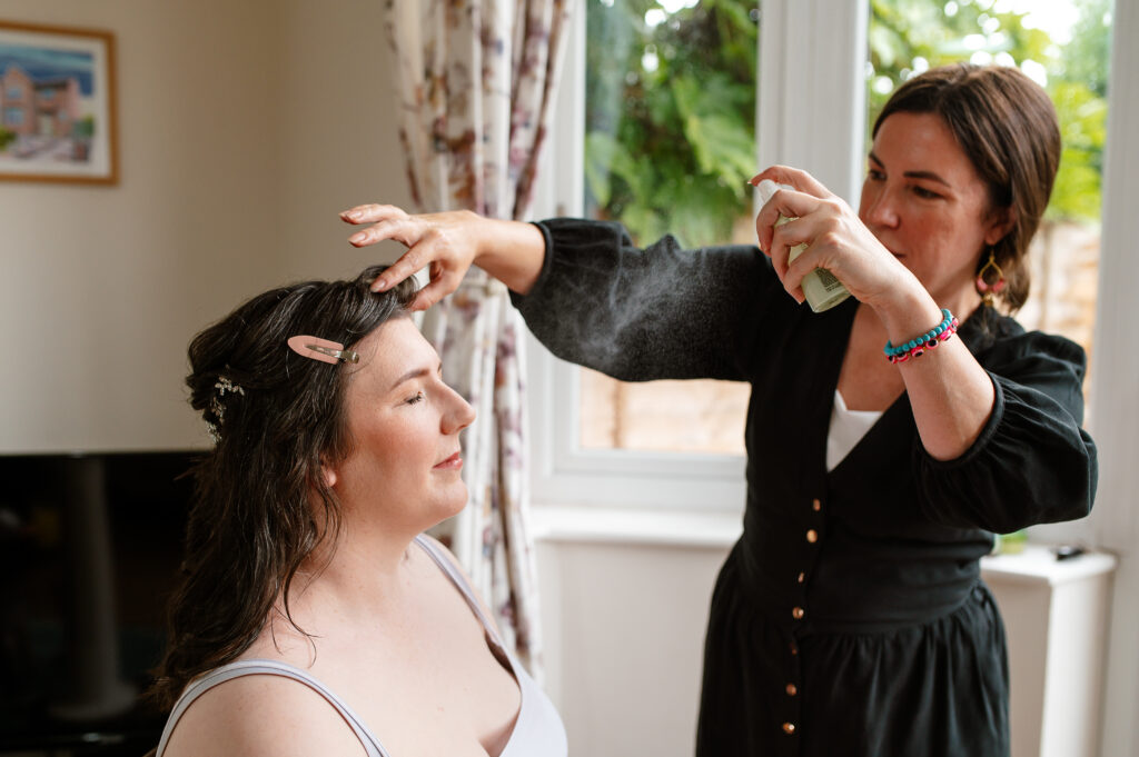 Image of wedding make up artist finishing bridal prep